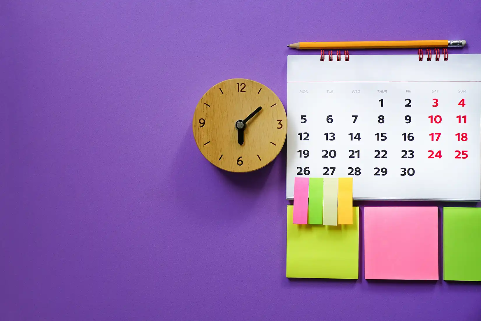 Close up of calendar and alarm clock on the purple table, planning for business meeting or travel planning